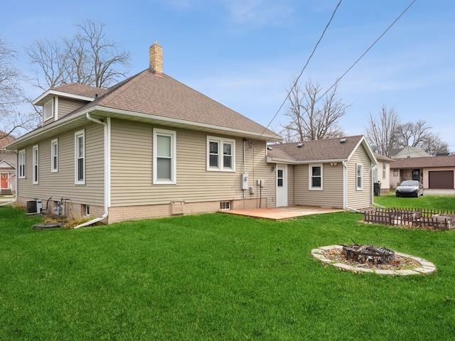 back of house featuring a yard, a fire pit, cooling unit, and a patio area