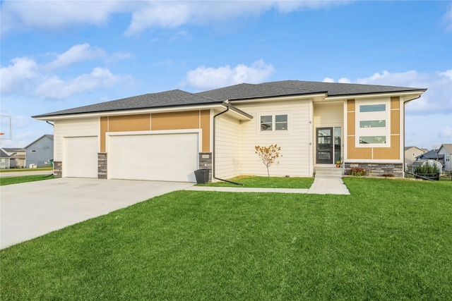 prairie-style house featuring a garage and a front yard