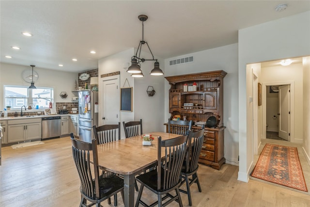 dining space with sink and light hardwood / wood-style floors