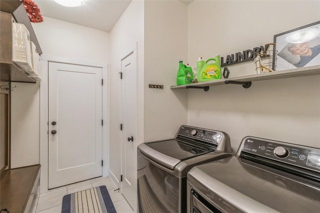 clothes washing area featuring independent washer and dryer and light tile patterned flooring