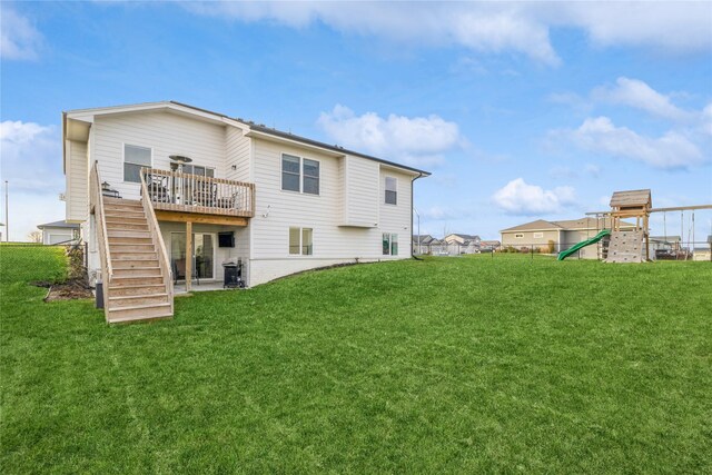 back of property featuring a playground, a wooden deck, and a yard