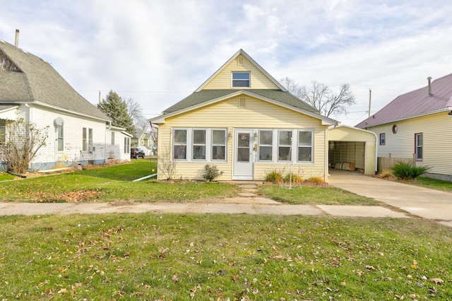 back of property with a lawn and a carport