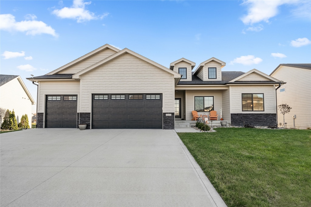 view of front of house featuring a porch, a front yard, and a garage