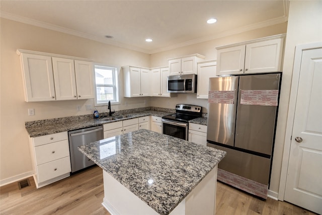 kitchen featuring white cabinets, a kitchen island, sink, and stainless steel appliances