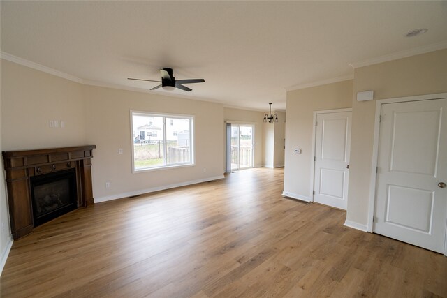 unfurnished living room featuring ceiling fan with notable chandelier, light hardwood / wood-style flooring, and ornamental molding