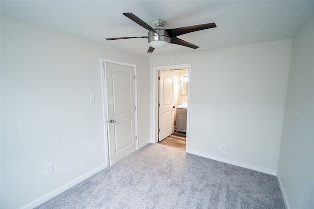 unfurnished bedroom with light carpet, connected bathroom, and ceiling fan