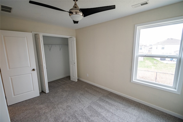 unfurnished bedroom featuring carpet floors, a closet, and ceiling fan