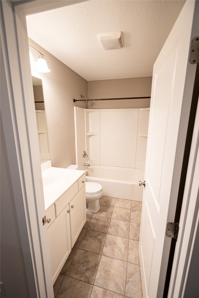 full bathroom with a textured ceiling, vanity, toilet, and shower / tub combination