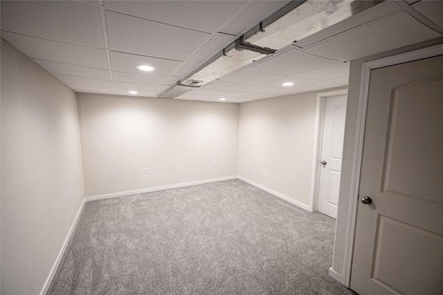 carpeted spare room with a drop ceiling