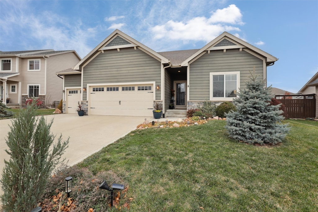 craftsman house with a front lawn and a garage