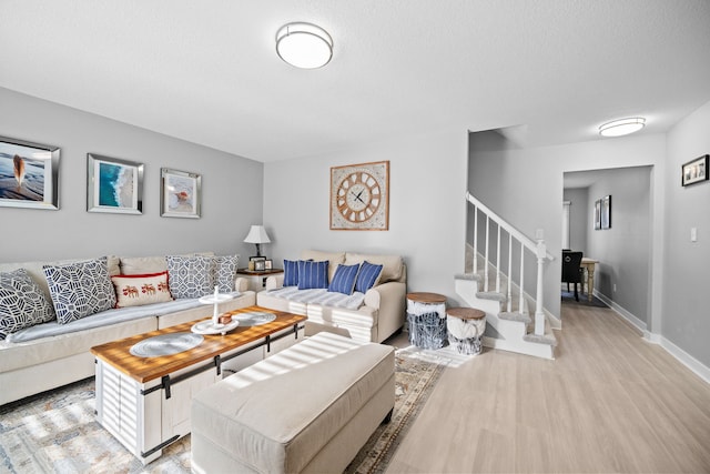 living room with light hardwood / wood-style floors and a textured ceiling