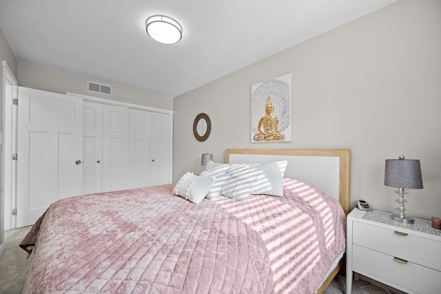 carpeted bedroom featuring a textured ceiling and a closet