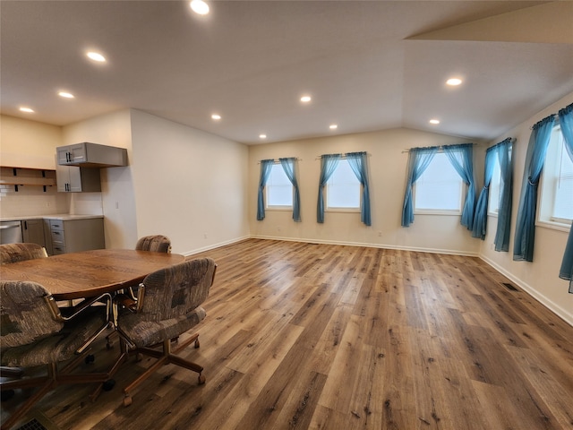 dining area with recessed lighting, baseboards, wood finished floors, and vaulted ceiling