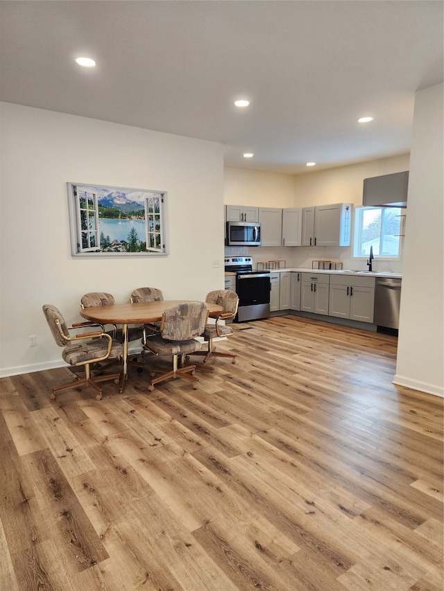 dining space with recessed lighting, light wood-type flooring, and baseboards