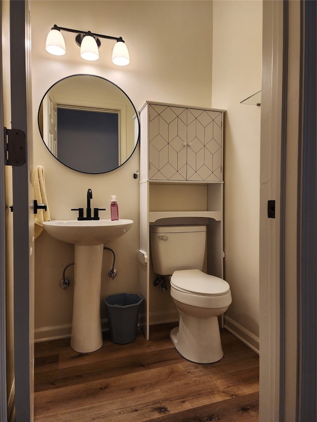 bathroom with wood-type flooring, toilet, and sink