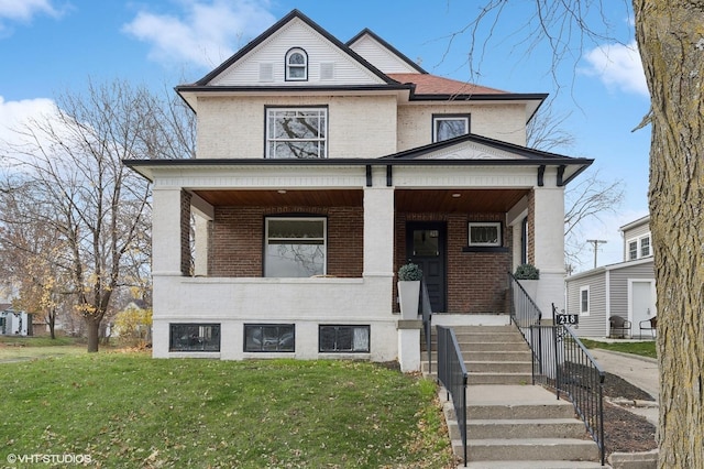 view of front of home featuring brick siding, a front lawn, and a porch