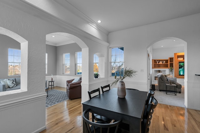 dining room with light hardwood / wood-style flooring, plenty of natural light, and crown molding