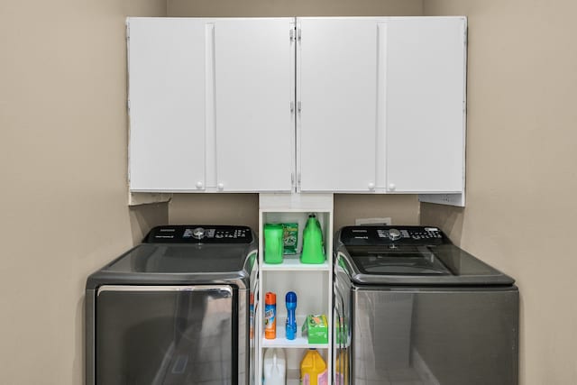 washroom featuring cabinets and independent washer and dryer