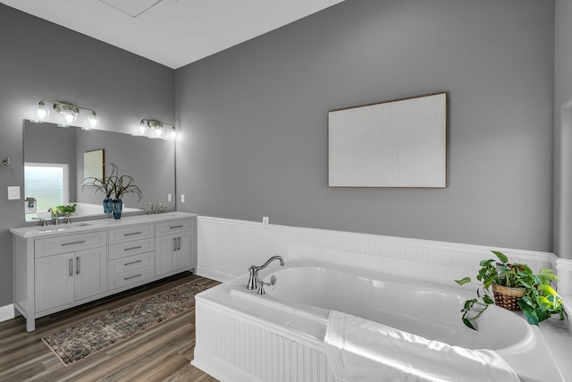 bathroom featuring vanity, wood-type flooring, and a tub to relax in