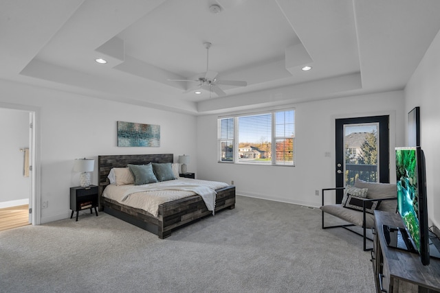 bedroom featuring a tray ceiling, ceiling fan, and light colored carpet