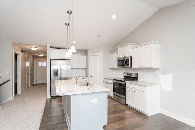 kitchen with sink, hanging light fixtures, vaulted ceiling, a kitchen island with sink, and appliances with stainless steel finishes