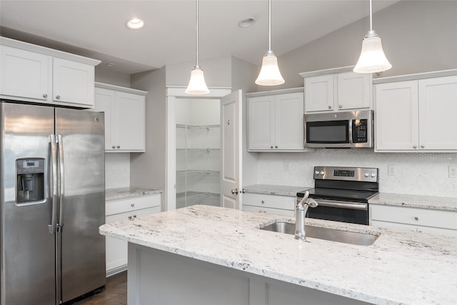 kitchen featuring light stone counters, white cabinetry, hanging light fixtures, and appliances with stainless steel finishes