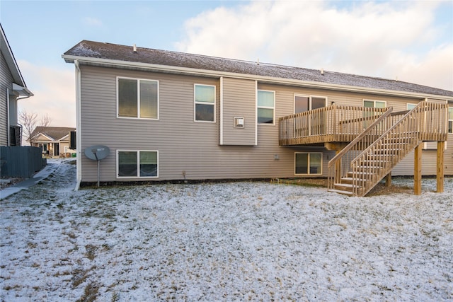 snow covered house featuring a deck