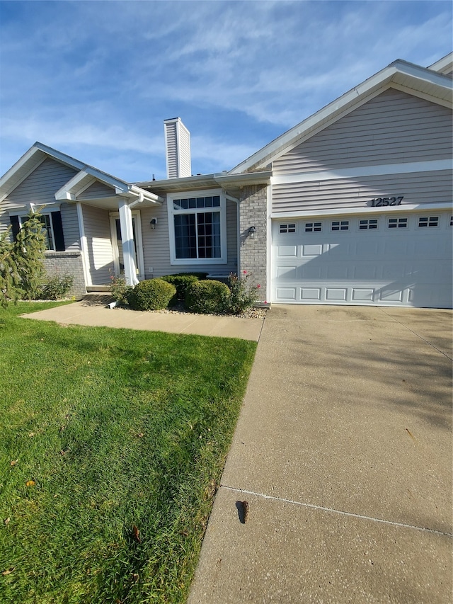 ranch-style house featuring a front lawn and a garage