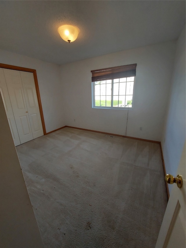 carpeted empty room with a textured ceiling