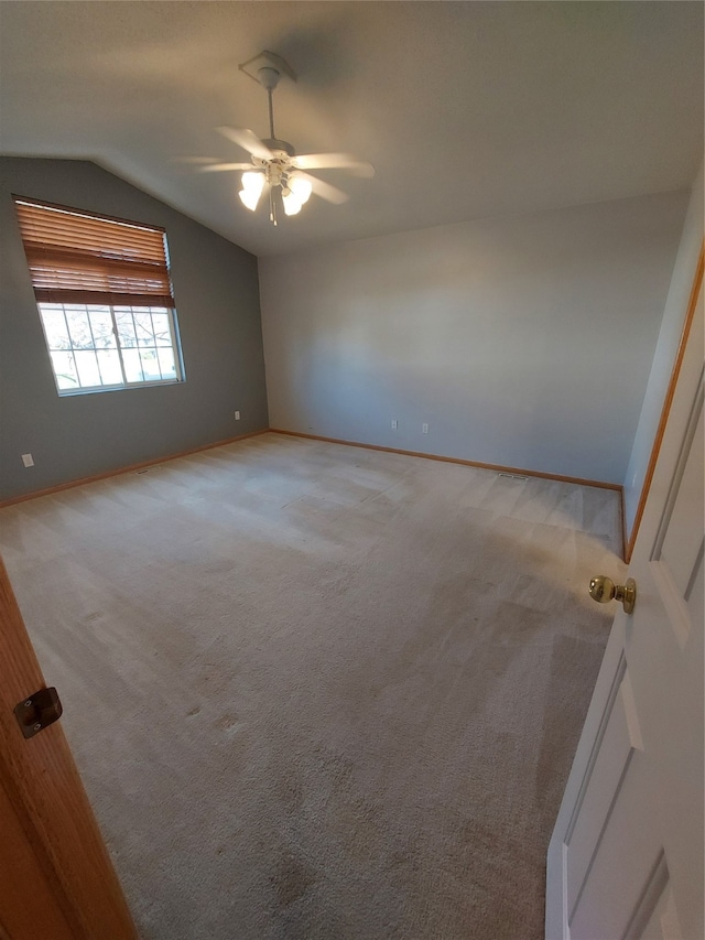 carpeted empty room with ceiling fan and lofted ceiling