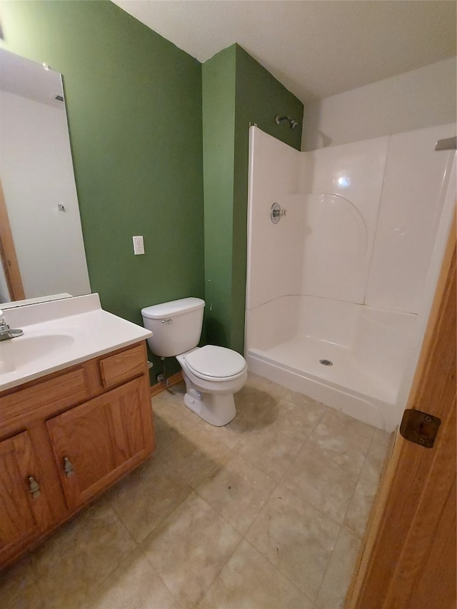 bathroom featuring a shower, vanity, and toilet