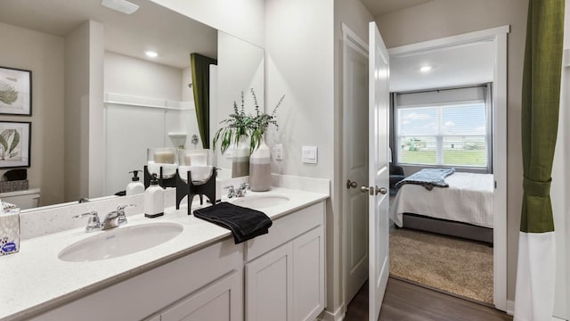 bathroom featuring toilet, vanity, and hardwood / wood-style floors