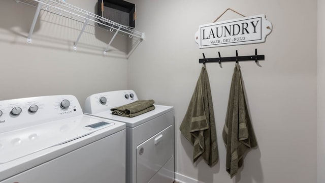 clothes washing area with washing machine and dryer