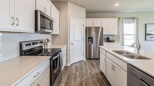 kitchen with sink, white cabinets, stainless steel appliances, and tasteful backsplash