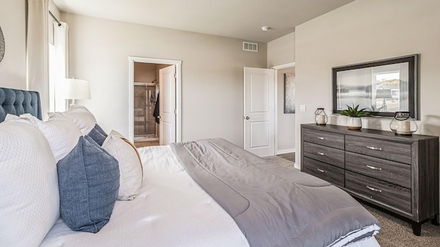 bedroom featuring ensuite bath and dark colored carpet