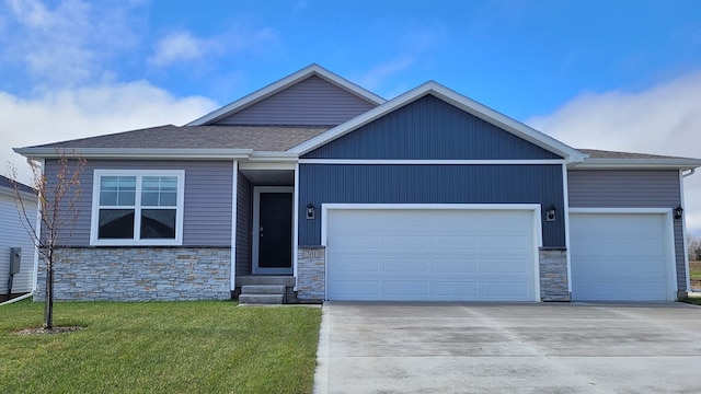 view of front of house featuring entry steps, an attached garage, concrete driveway, roof with shingles, and a front lawn