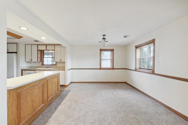 kitchen featuring light colored carpet, white appliances, and sink