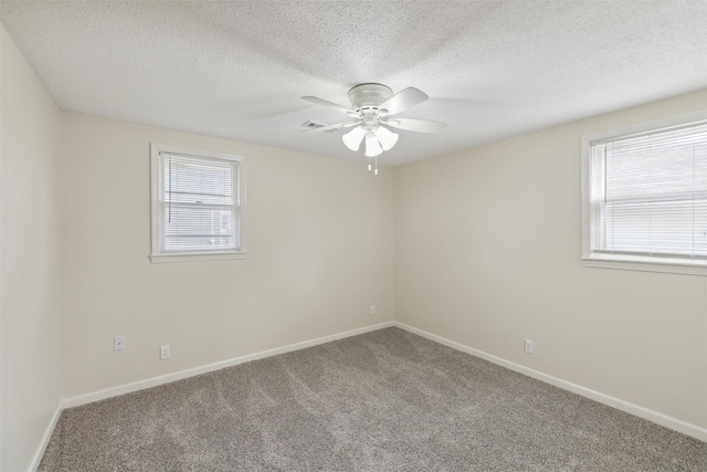 carpeted spare room with a textured ceiling and ceiling fan