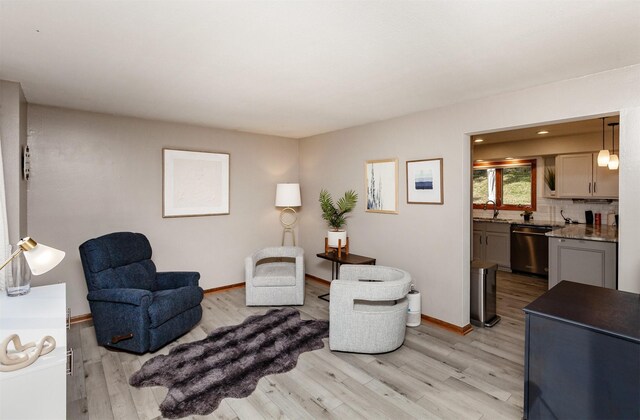 sitting room featuring sink and light hardwood / wood-style floors