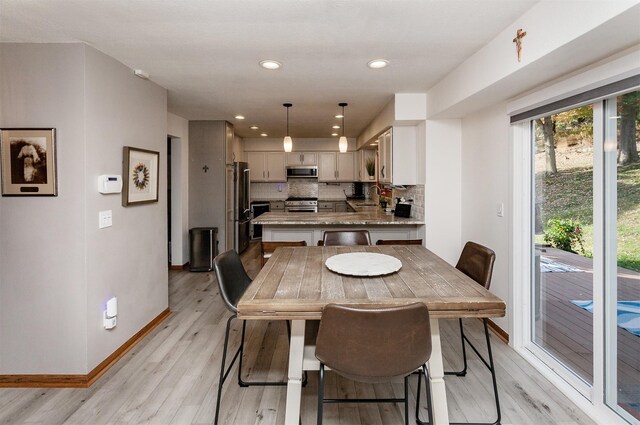 dining space with sink and light hardwood / wood-style floors