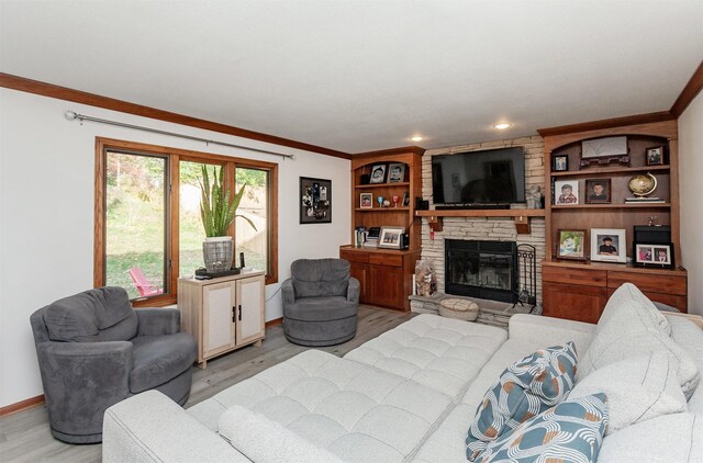 living room with crown molding, a fireplace, and light hardwood / wood-style floors