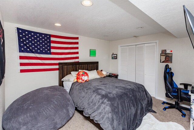 carpeted bedroom with a textured ceiling and a closet