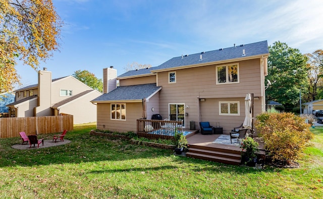 rear view of house featuring a deck and a lawn