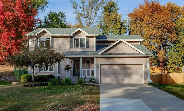 view of front of property featuring a garage, covered porch, and a front lawn