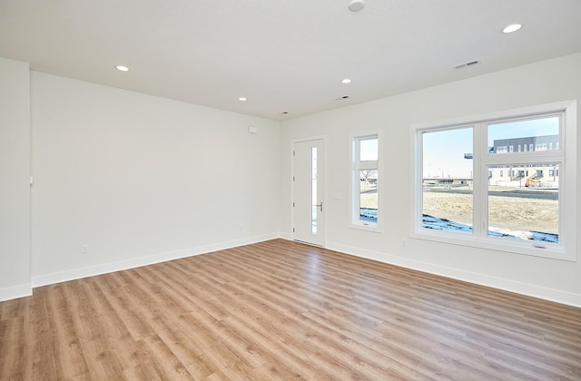 empty room with light hardwood / wood-style flooring