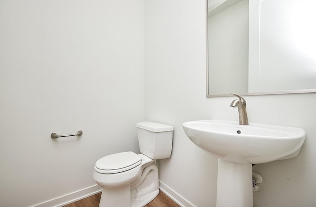 bathroom with sink, toilet, and hardwood / wood-style flooring