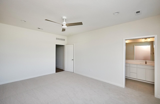 carpeted empty room with a textured ceiling, ceiling fan, and sink