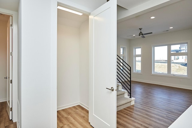 stairs featuring hardwood / wood-style floors and ceiling fan