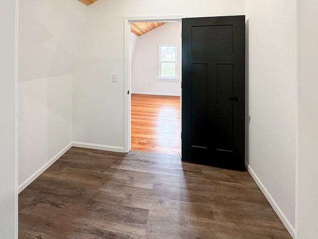 interior space with dark hardwood / wood-style flooring and lofted ceiling