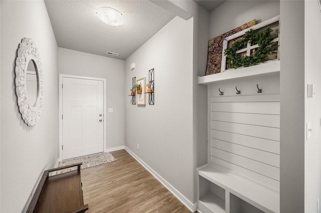 mudroom featuring light hardwood / wood-style floors and a textured ceiling